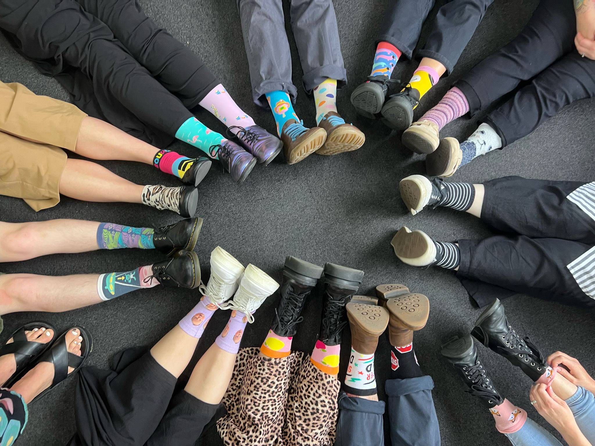 Positive Behaviour Support Melbourne — Rubix Support Diverse group of people sitting in a circle showing different shoes and legs representing inclusive Positive Behaviour Support in Melbourne
